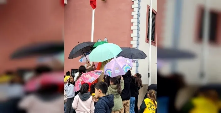 Duygulandıran anlar: Minik öğrenciler yağmura rağmen Atatürk büstünü şemsiyeleriyle korudu